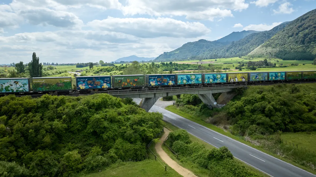 Containers with environmental artwork travelling over bridge