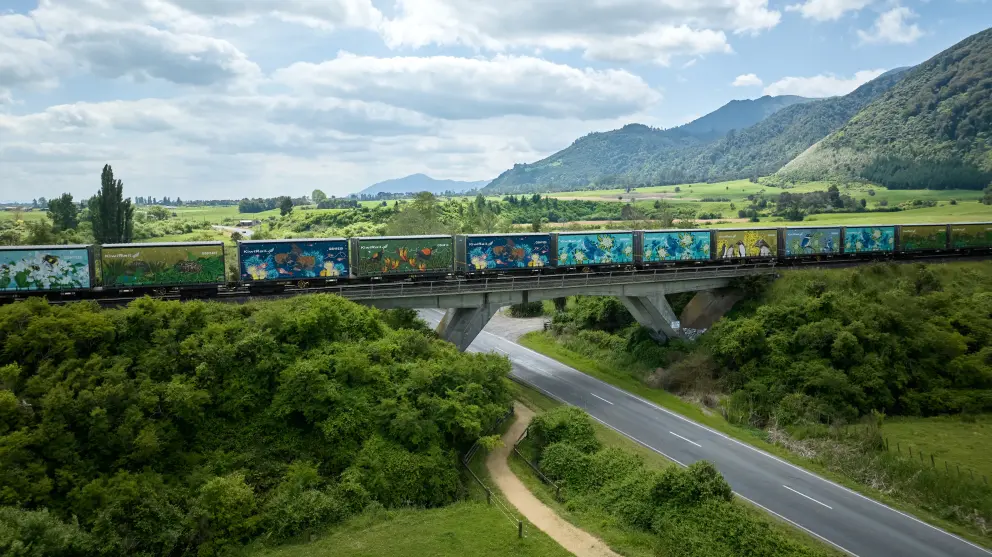 Containers with environmental artwork travelling over bridge