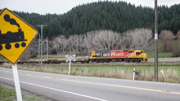 Freight train travelling over rural crossing