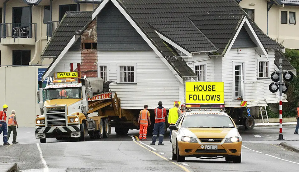 House being transported via truck over crossing